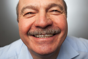 Elderly man laughs from ear to ear, giggles on the funny stories. Be happy of news or events