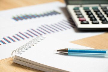 Note paper with pen, graph, calculator background