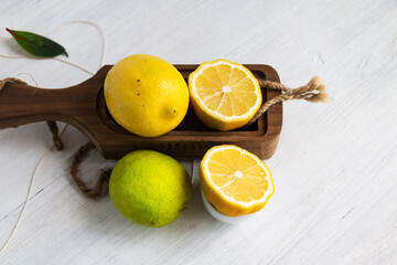 Lemon and lime - citrus fruits - on white wooden table.
