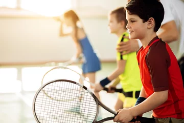 Poster Im Rahmen Excited children playing tennis on court © Yakobchuk Olena