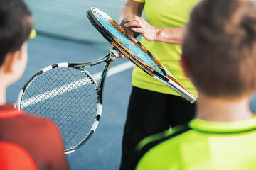 Trainer showing sports equipment to kids © Yakobchuk Olena