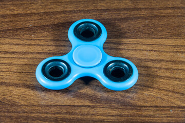 Fidget Spinner in wooden isolated background for stress release during work