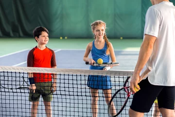 Zelfklevend Fotobehang Male tennis trainer teaching children © Yakobchuk Olena