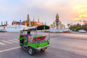 Fototapeta premium Tuk-tuk do samochodów osobowych na zwiedzanie wokół Wielkiego Pałacu w Bangkoku na tle zachodzącego słońca