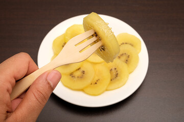 Slice of yellow kiwi(gold kiwi) on plate.