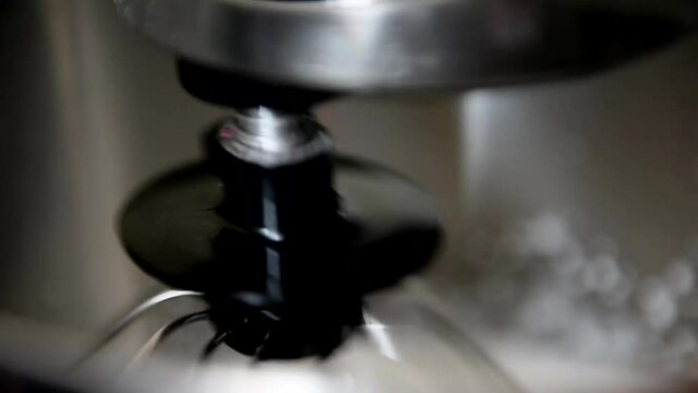 The process of whipping cream in the bowl of a professional mixer. The image is out of focus