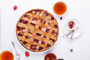 Toasted rye rhubarb pie with strawberry on white background with copy space. Summer tea time concept.
