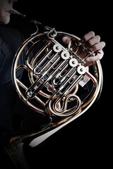 French horn instrument. Player hands playing horn music