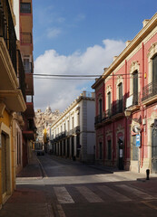 Light and shadow on the narrow crossroad in old town, built of multicolored brick houses. Spain, Almeria.Intersection