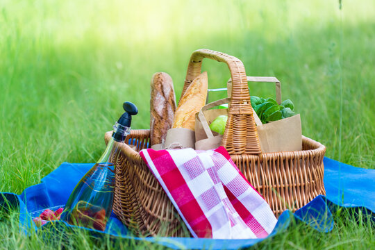 Summer basket for picnic  with wine, bread, fruits and snacks