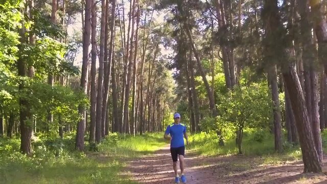 young athlete on a morning jog in the forest. slow motion