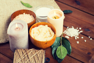close up of natural body scrub and candles on wood