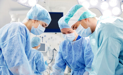 group of surgeons in operating room at hospital - obrazy, fototapety, plakaty