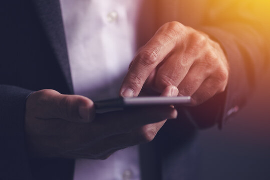 Close up of male businessman hands using mobile phone