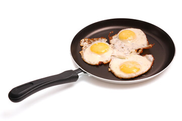 The frying pan with fried eggs isolated on the white