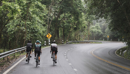 Cyclist Asian men are cycling road bike morning uphill on the road in Chiang Mai Thailand