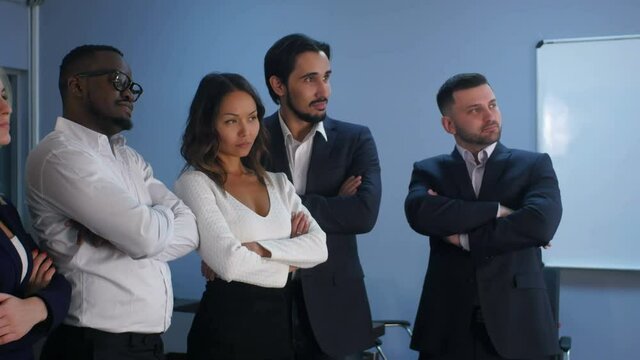 Business team standing with serious look in office