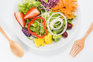 Fresh healthy salad dish with wooden spoon and fork. Isolated on white background