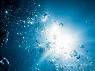 Bubbles in underwater and sun light in blue ocean. Water texture.