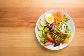 Fresh healthy salad on wooden table. View from above with copy space