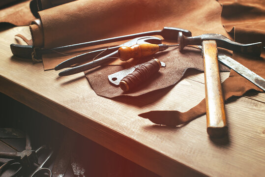 Cobbler tools in workshop on the wooden table . Top view.