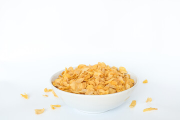 Corn flakes falling in bowl isolated on white background