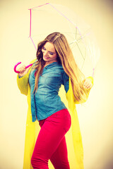 Woman wearing waterproof coat under umbrella