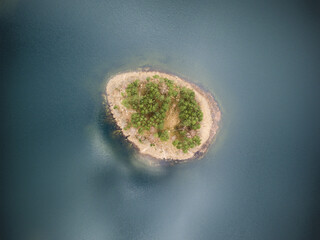   Idyllic aerial view with a secluded island in the middle of the lake with no borders of coastline visible.