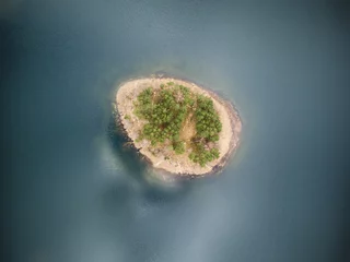 Papier Peint photo Photo aérienne   Idyllic aerial view with a secluded island in the middle of the lake with no borders of coastline visible.