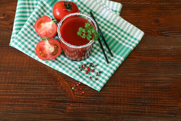 Tomato juice, tomatoes, spices on a wooden background.