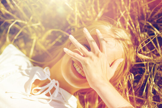 happy young woman lying on cereal field