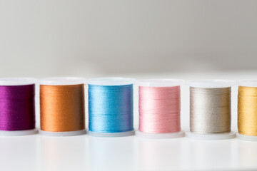 row of colorful thread spools on table