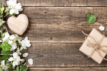 Obraz na płótnie Canvas Spring blossom, stone heart and gift box on wooden desk