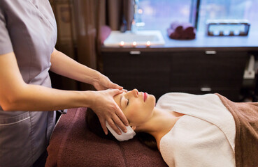woman having face and head massage at spa parlor