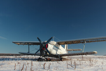 Old plane on parking in the middle of the winter field. © esalienko