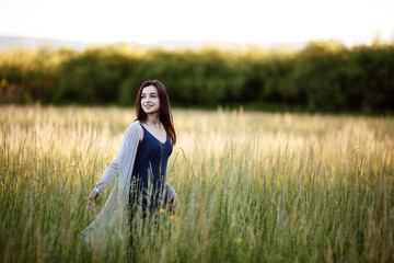Beautiful happy woman walking in the summer rural meadow. Happy beautiful woman in meadow. Freedom concept background