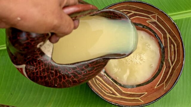 Mujer sirviendo chicha en cer&aacute;mica ancestral amaz&oacute;nica 