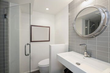 Clean modern bathroom with tiled wall and round mirror