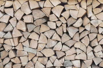 The firewood is stacked in a woodpile. Decorative wall of firewood