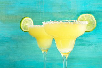 Lemon Margarita cocktails on vibrant turquoise with copyspace