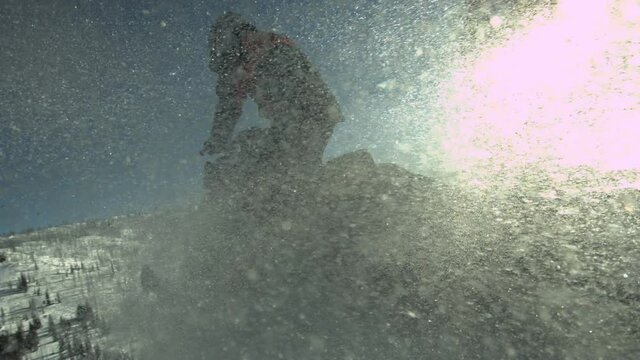 Snowmobile jumping with powder snow in super slow motion