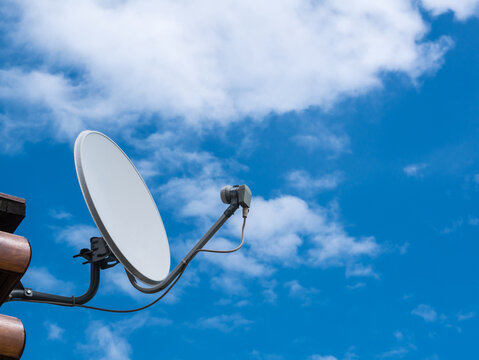 small satellite antenna on the blue sky and clouds background