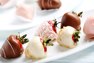 Strawberries covered in chocolate on a blue wooden table