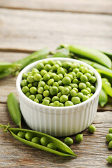 Green peas on a grey wooden table