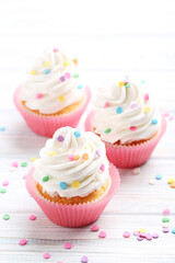 Tasty cupcakes on a white wooden table