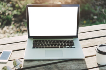 Mockup image of laptop with blank white screen on vintage wooden table in outdoor cafe