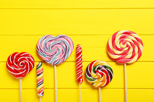 Sweet lollipops on a yellow wooden table