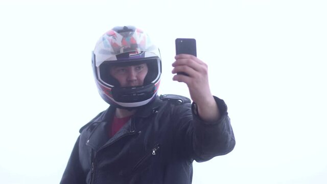 Handsome biker in helmet taking selfie