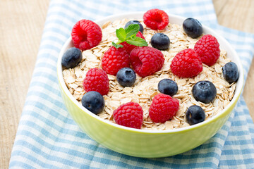 Oatmeal porridge with berries. Raspberries and blueberries.