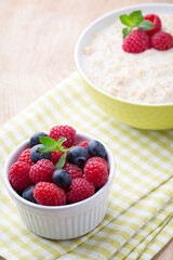 Oatmeal porridge in bowl with berries raspberries and blackberries.